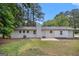 View of the backyard of the house with lush greenery, a patio, and a well-maintained lawn at 125 Lafayette Dr, Fayetteville, GA 30214