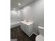 Modern bathroom with white vanity, white marble tile surround, and dark wood floors at 125 Lafayette Dr, Fayetteville, GA 30214
