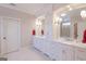 Bathroom featuring double vanities, marble countertop, white cabinets, and decorative lighting at 319 Beaconsfield Dr, Sharpsburg, GA 30277