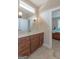 Bathroom featuring wood vanity, tile floors, large mirror, and doorway leading to bedroom at 319 Beaconsfield Dr, Sharpsburg, GA 30277