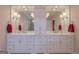 Bathroom featuring double vanities, marble countertop, white cabinets, and decorative mirrors at 319 Beaconsfield Dr, Sharpsburg, GA 30277