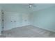 Carpeted bedroom with a ceiling fan, bright window and three white closets at 319 Beaconsfield Dr, Sharpsburg, GA 30277