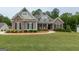 Charming home featuring stone accents, manicured landscaping, and a welcoming walkway at 319 Beaconsfield Dr, Sharpsburg, GA 30277