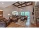 Spacious living room with wood floors, stone fireplace, coffered ceilings, and a large sectional sofa at 319 Beaconsfield Dr, Sharpsburg, GA 30277