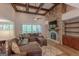Living room showcasing a stone fireplace, built-ins, wood floors, and a large sectional sofa at 319 Beaconsfield Dr, Sharpsburg, GA 30277