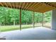Open patio space with wooded views and exposed beam ceiling offers flexible outdoor living space at 319 Beaconsfield Dr, Sharpsburg, GA 30277