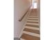 Wooden staircase with white risers and a wooden handrail at 319 Beaconsfield Dr, Sharpsburg, GA 30277