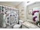 Well-lit bathroom with toilet, vanity, mirror and shower with stylish patterned shower curtain at 701 Monticello Ln, Mcdonough, GA 30253