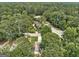 Overhead shot of a house with mature trees, showcasing the property's neighborhood and surrounding greenery at 203 First Leaf, Peachtree City, GA 30269