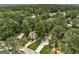 An aerial view of a single-Gathering home, featuring a well-maintained lawn, mature trees, and a long driveway at 203 First Leaf, Peachtree City, GA 30269