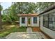 Charming backyard studio with a yellow door, surrounded by lush greenery and a tranquil patio area at 203 First Leaf, Peachtree City, GA 30269