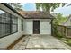 Charming backyard with patio and a home's back entrance with a black door surrounded by lush greenery at 203 First Leaf, Peachtree City, GA 30269