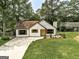 Charming exterior of a one-story home with white siding, brown shutters, and a lush green lawn at 203 First Leaf, Peachtree City, GA 30269