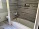 Bathroom with gray tiling surrounding the shower-tub, and a toilet nearby at 8832 Twin Oaks Dr, Jonesboro, GA 30236