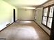 Spacious living room with large windows and worn carpet at 8832 Twin Oaks Dr, Jonesboro, GA 30236