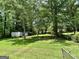 Expansive, green backyard surrounded by lush trees offering shade and privacy at 3683 Miller St, Lithia Springs, GA 30122
