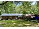 Charming single-story home with a brick facade, metal roof, and a spacious, green lawn and mature trees at 3683 Miller St, Lithia Springs, GA 30122
