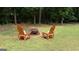 Backyard with a central fire pit and two wooden Adirondack chairs with white cushions at 10 Stagg Trce, Social Circle, GA 30025