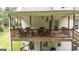 Comfortable second story deck with wooden railings, seating area, and French door access to the house at 10 Stagg Trce, Social Circle, GA 30025