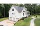 Stylish house with a three-car garage and a cozy front porch adorned with patriotic decorations and vibrant flowers at 10 Stagg Trce, Social Circle, GA 30025