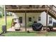 Lower level outdoor patio featuring a grill, smoker, and cozy swing seating underneath a wooden deck at 10 Stagg Trce, Social Circle, GA 30025