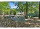 Expansive backyard with a stone patio, seating, and mature trees offering shade at 1000 Turner Church Rd, Mcdonough, GA 30252