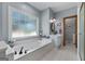 Well-lit bathroom boasting a soaking tub, window, and a single sink vanity at 1000 Turner Church Rd, Mcdonough, GA 30252