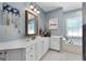 Bathroom features white cabinets, double sinks, a soaking tub, and natural light from a window at 1000 Turner Church Rd, Mcdonough, GA 30252