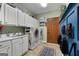 Practical laundry room with white cabinets, utility sink, washer and dryer, and a mudroom area at 1000 Turner Church Rd, Mcdonough, GA 30252