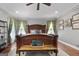 Bright main bedroom showcasing a wooden bed frame with bench and patterned curtains at 1000 Turner Church Rd, Mcdonough, GA 30252