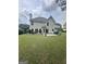 Spacious backyard view of a two-story home, with a well-maintained lawn, and patio area at 3381 Walkers Ridge Rd, Dacula, GA 30019