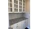 Butler's pantry featuring white cabinets, granite counters, and white marble backsplash at 3381 Walkers Ridge Rd, Dacula, GA 30019