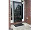Front entrance with a black storm door, brick facade, and concrete step at 3381 Walkers Ridge Rd, Dacula, GA 30019