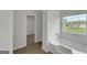 Bright bathroom featuring wood-look flooring, white tiling, and a soaking tub at 907 Brisley Cir, Hampton, GA 30228