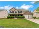 Charming two-story brick home with a well-manicured lawn, black shutters, and a two-car garage at 907 Brisley Cir, Hampton, GA 30228