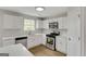 Bright kitchen featuring stainless steel appliances, white cabinets, and hardwood floors at 907 Brisley Cir, Hampton, GA 30228