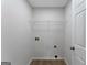 Clean laundry room with wood-look floors, wire shelf, and white door at 907 Brisley Cir, Hampton, GA 30228