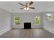 Bright living room featuring hardwood floors, a fireplace, and dual windows at 907 Brisley Cir, Hampton, GA 30228