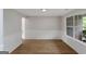 Bright, empty living room with new vinyl flooring, wainscotting and a large window at 907 Brisley Cir, Hampton, GA 30228