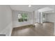 Bright, empty living room with new vinyl flooring, wainscotting and a large window at 907 Brisley Cir, Hampton, GA 30228