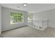 Bright upstairs loft with large windows, white railing, and neutral carpet at 907 Brisley Cir, Hampton, GA 30228