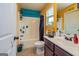 Bright bathroom with yellow and blue walls, complete with shower and dark vanity, offering a cheerful and functional space at 150 Bellemeade Ct, Fayetteville, GA 30215