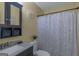 Well-lit bathroom features a sink, toilet, and shower with a lovely floral patterned curtain at 3823 Rock Hollow Ct, Conley, GA 30288