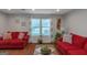 Bright living room featuring hardwood floors, two red sofas, and a view to the exterior at 3823 Rock Hollow Ct, Conley, GA 30288