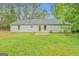 Back exterior of single story home featuring patio, well maintained lawn and trees at 4547 Atha Cir, Loganville, GA 30052