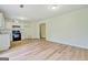Open-concept living room with modern appliances, white cabinets, and laminate flooring at 4547 Atha Cir, Loganville, GA 30052