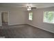 Spacious living room with new floors, neutral walls, a ceiling fan, and natural light from two windows at 6286 Saddlewood Dr, Lithonia, GA 30058