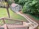 Backyard shed with stone pathway and palm tree landscaping, viewed from wood deck stairs at 10875 Shagbark Trl, Roswell, GA 30075