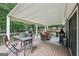 Covered deck offers outdoor dining and relaxing area with a grill at 10875 Shagbark Trl, Roswell, GA 30075