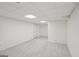 Clean basement features neutral carpeting, white walls, a drop ceiling, and a door to the exterior at 10875 Shagbark Trl, Roswell, GA 30075
